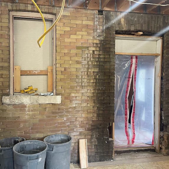 A window and a door in a brick wall